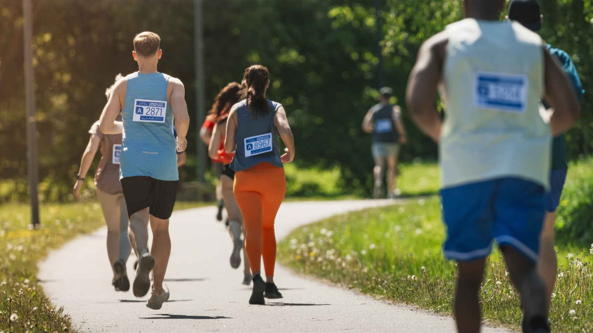 Runners round a corner in a summertime race event.